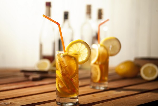Long island ice tea cocktails on wooden and white background.